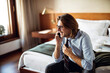 © Marko Geber - Middle aged businessman talking on a phone in a hotel room