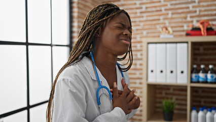 Canvas Print - African american woman doctor suffering heart attack at the clinic