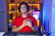© Krakenimages.com - Young hispanic man playing video games smiling with hands on chest with closed eyes and grateful gesture on face. health concept.