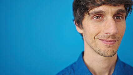 Poster - Young hispanic man smiling over isolated blue background