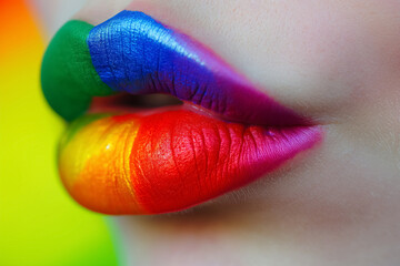 Wall Mural - Close-up of lips artistically painted with the colors of the rainbow on a bright background.