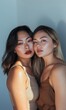 © Jordan - two beautiful asian women sisters natural pose against a neutral blue background in studio