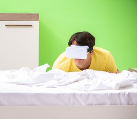 Wall Mural - Young man with virtual glasses in the bedroom