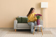 © Pixel-Shot - Pretty young woman and vase with bouquet of beautiful purple tulips at home