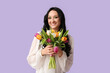 © Pixel-Shot - Beautiful young woman with bouquet of tulips on lilac background. International Women's Day