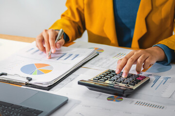 Fototapete - Female accountant using calculator and computer with pen in office. concept finance and accounting