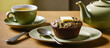 Single serving zucchini banana flaxseed muffin, topped with butter, on small plate with butter knife. Cups of tea and green tea pot in the background. Banner, Wallpaper, Background, Header, Marketing.