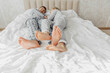 © inna717 - the bare, clean feet of two children, offspring, lying side by side under the same blanket on the bed. morning relaxation, cozy rest. cute pictures of baby feet