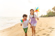 © CandyRetriever  - Happy Asian family travel ocean on summer holiday vacation. Little child boy and girl sibling walking and playing together on the beach at sunset. Children kid have fun outdoor lifestyle at the sea.