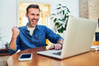 © baranq - Excited adult man celebrating online investment success using laptop at home