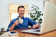© baranq - Carefree adult man using laptop at home browsing internet