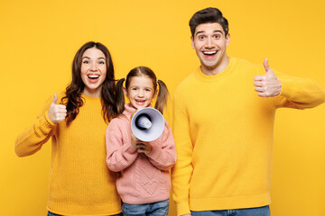 Poster - Young parents mom dad with child kid girl 7-8 years old wear pink sweater casual clothes hold megaphone scream about sale Hurry up show thumb up isolated on plain yellow background Family day concept