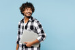 © ViDi Studio - Young happy Indian IT man he wears shirt white t-shirt casual clothes hold closed laptop pc computer look aside isolated on plain pastel light blue cyan background studio portrait. Lifestyle concept.