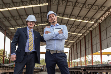 Two civil engineers from different cultures stand with confident for their prefabs business program. Two smart mangers stand in front of their readymade floor factory