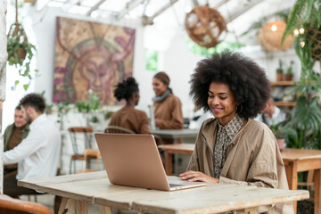 Woman Sitting at Table Using Laptop Computer