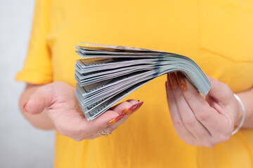 woman's hands holding American dollar paper bills