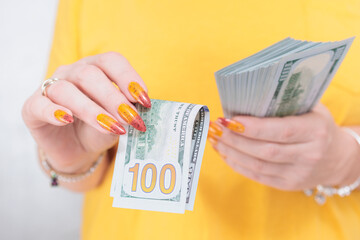 woman's hands holding American dollar paper bills