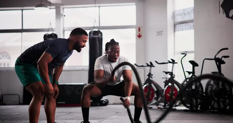 Wall Mural - Man, personal trainer and fitness with battle rope at gym for workout, exercise or muscle endurance in motivation. Active male person or athlete with coach in stamina, cardio or intense training