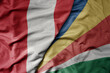 big waving national colorful flag of seychelles and national flag of peru .