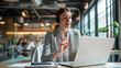 © Studio Nova - woman is engaging in a video call or virtual meeting, gesturing with her hands, with earphones in, and looking intently at the laptop screen in a modern office setting