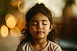 Close up little indian girl sits with her eyes closed relaxingly meditating in the room, children's mental health and relaxation concept	
