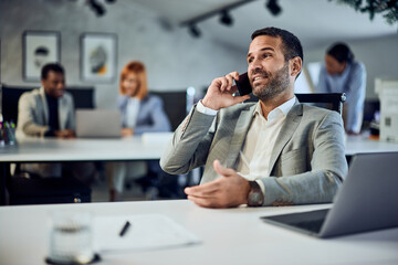 a businessman talking to someone over the mobile phone while working in the co-working office.