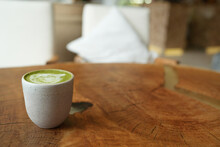Top View Of Matcha Green Tea Latte With A Latte Heart Art On Wooden Table Cafe Background