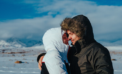 Sticker - Young romantic couple embracing on mountains background in winter