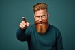 © Oleg Kozlovskiy - A man with a striking red beard and styled hair winks and points towards the camera, displaying a playful and engaging demeanor against a teal background