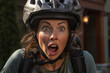 Junge Frau mit Helm, lachende Frau fährt mit dem Fahrrad durch die Stadt