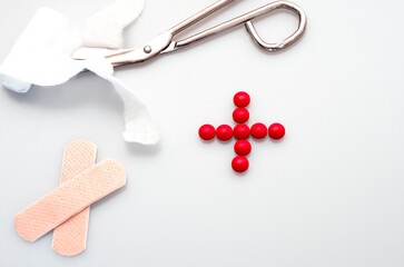 medicine concept, instruments used in medicine, scissors cutting a band aid, patch and red sign for 