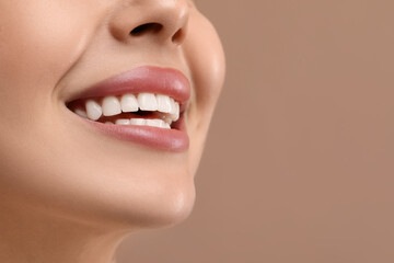Wall Mural - Woman with clean teeth smiling on beige background, closeup. Space for text