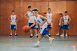© Zamrznuti tonovi - A junior basketball player dribbling a ball and practicing on court.