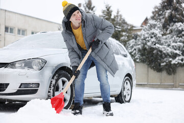 Canvas Print - Man removing snow with shovel near car outdoors