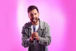 © New Africa - Handsome man with microphone singing on pink background