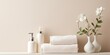 Beige pastel bathroom interior with white shelf, towels, soap, perfume bottle, and cotton plant. Space for text. Minimalistic.