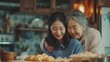 Asian lovely family, young daughter look to old mother cook in kitchen. Beautiful female enjoy spend leisure time and hugging senior elderly mom bake croissant on table in house. Activity relationship