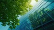 © buraratn - Eco-friendly building in the modern city. Green tree branches with leaves and sustainable glass building for reducing heat and carbon dioxide. Office building with green environment. Go green concept.