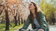 © buraratn - Young pensive dreamful happy woman 20s wearing casual green jacket jeans riding bicycle bike on sidewalk in city spring park outdoors, look aside. People active urban healthy lifestyle cycling concept