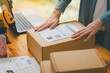 © photobyphotoboy - startup young female small business owners attaching shipping labels to cardboard boxes or parcels for delivery of customer orders-concept shopping online.