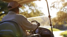 Back View Of A Man Driving A Golf Cart During Golden Hour