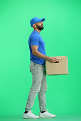 A male deliveryman, on a green background, full-length, with a box