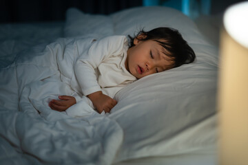 Wall Mural - toddler baby sleeping on bed at night