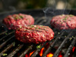 Seasoned Raw Meat Formed into Burger Patties Cooking on a Hot Grill