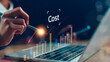 © FAMILY STOCK - Cost reduction concept. Businesswoman pointing down arrow of the graph with cost reduction business finance on virtual screen. Business, technology, cost management, cut budget.