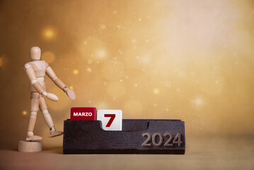 Calendar glow in March: Wooden character highlights the seventh day against a backdrop of warm, bright tones.