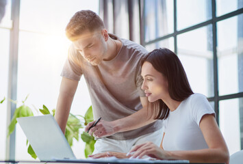 male ceo executive manager mentor giving consultation on financial operations to female colleague using laptop