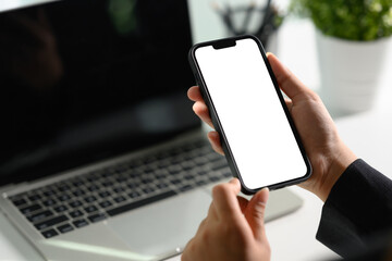 Cropped shot businessman using mobile phone at office desk. Empty screen for your text message