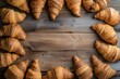 Top view of various fresh French croissants on a frame shape leaving a useful copy space at the center of the image 