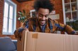 Low angle view of a cheerful multiracial young man at home opening a cardboard box and putting out a cobalt blue running long sleeve top mens. 